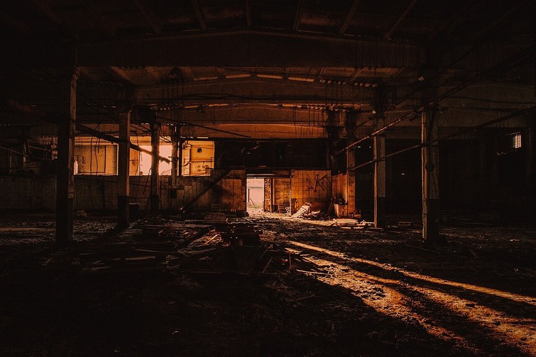 Dark abandoned factory interior with warm light used as a consistent 3:2 urbex blog image