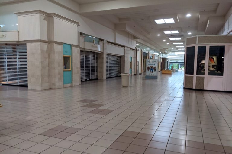 Abandoned mall interior with empty corridors and closed storefronts