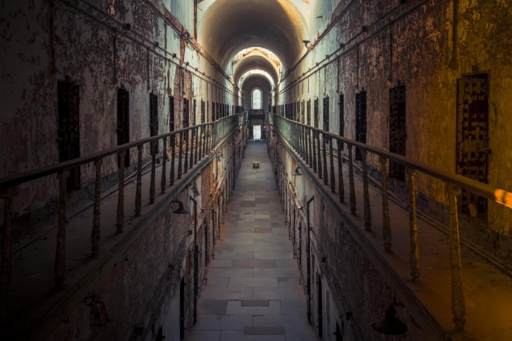 Abandoned prison cell block corridor used for responsible urbex research planning